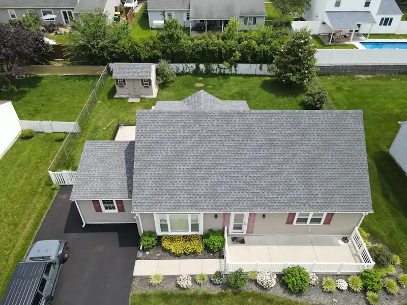 Aerial view of a suburban house with a grey shingle roof