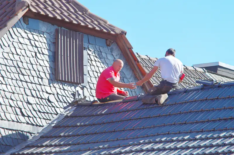 Two roofers working on a residential roof